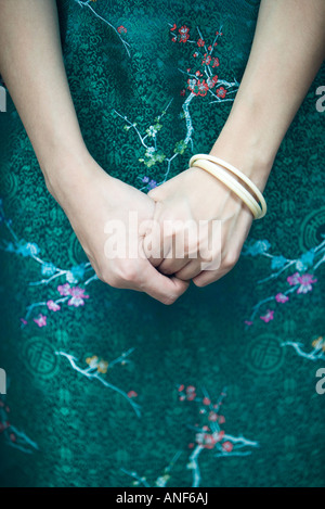 Young woman dressed in traditional Chinese clothing, hands clasped, close-up, cropped view Stock Photo