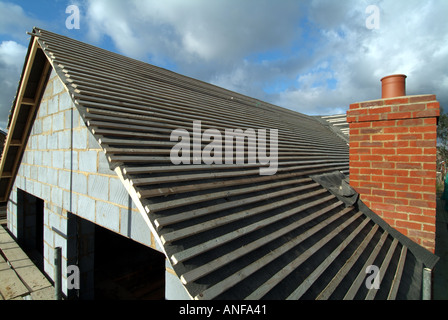 Work in progress on detached house under construction roof works including gable end felt battens and general preparation for plain tiles England UK Stock Photo