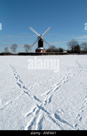 Mountnessing in working windmill order snow covered village green after snowfall with early morning walkers footprints Brentwood Essex England UK Stock Photo