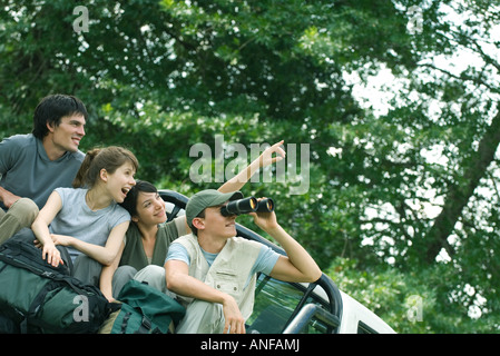 Young hikers in back of pick-up truck, looking at something out of frame Stock Photo
