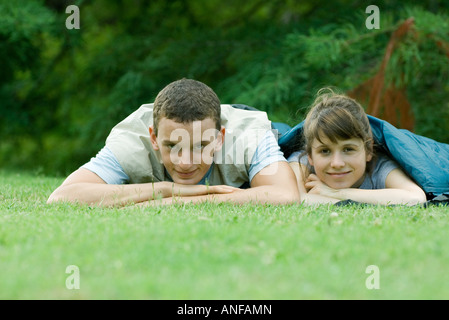 Young campers in sleeping bags, smiling at camera Stock Photo