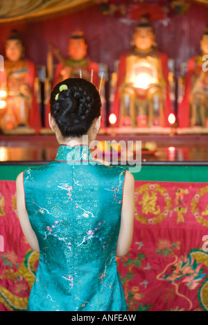 Young woman wearing traditional Chinese clothing, in front of shrine, rear view Stock Photo