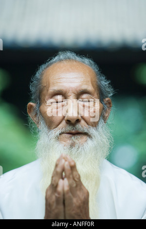 Elderly man praying Stock Photo