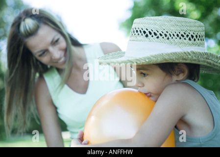 Boy and mother blowing up balloons Stock Photo - Alamy