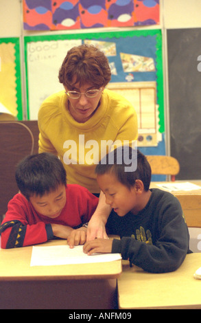 Summer school white teacher 25 with Asian American students age 9. Holland School Minneapolis Minnesota USA Stock Photo