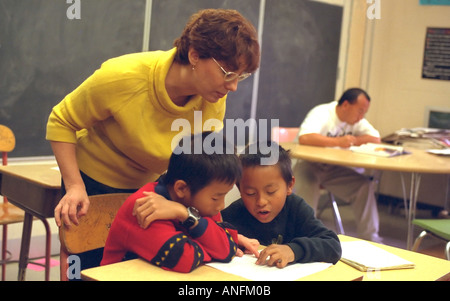 Summer school white teacher 25 with Asian American students age 9. Holland School Minneapolis Minnesota USA Stock Photo