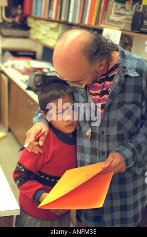 White teacher age 50 comforting frustrated Asian American summer school student age 8. Holland School Minneapolis Minnesota USA Stock Photo