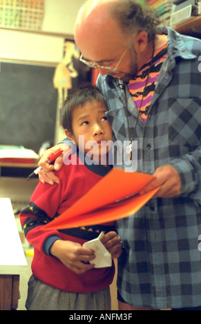 Teacher age 50 comforting frustrated summer school student age 9. Holland School Minneapolis Minnesota USA Stock Photo