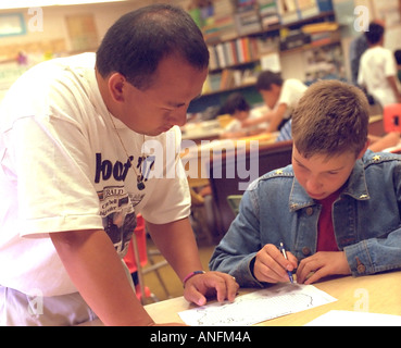 Asian American teacher age 25 working with student 12 at catch up summer school. Holland School Minneapolis Minnesota USA Stock Photo