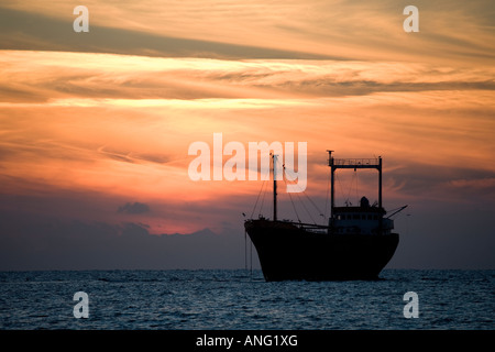 Beached, grounded silhouetted shipwrecked vessel; Cargo ship Honduran-flagged M/V Demetrios II at sunset which ran aground in Pathos Cyprus in 1998 Stock Photo