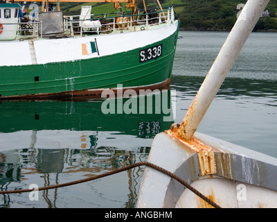 Bows of two fishing boats moored in the harbour of Union Hall West Cork Ireland with reflections in the water Stock Photo