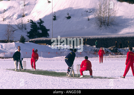 Cricket match being played by two English teams on the snow covered frozen Lake St Moritz in the sunshine at St Moritz Switzerland Europe Stock Photo