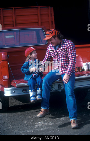 Father And Son Sitting On Tailgate Of Removal Truck Having Drink On ...