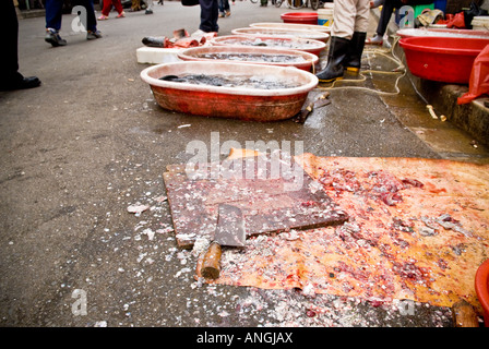 Fish scales blood covered cutting board and knife on street in Chinese market, Shanghai, China Stock Photo