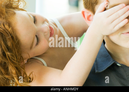 Girl covering her friend's eyes from behind, cropped view Stock Photo