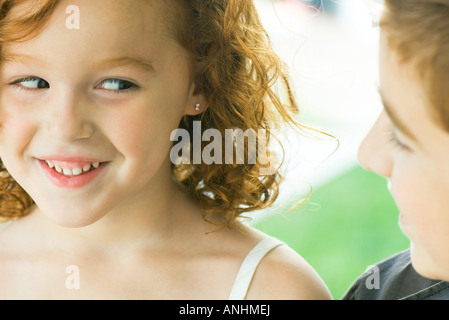 Girl smiling at brother, cropped view Stock Photo