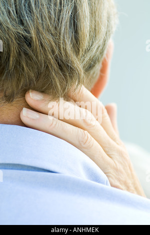 Cropped rear view of hand touching man's neck Stock Photo