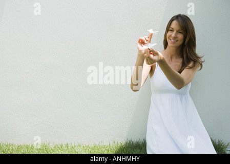 Woman in sundress holding fake butterflies, smiling Stock Photo