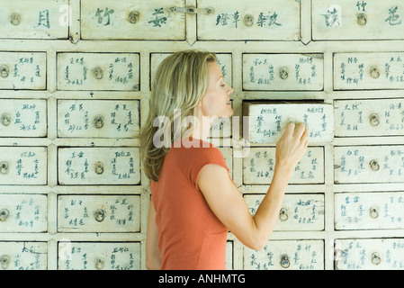 Woman opening drawer in piece of furniture Stock Photo