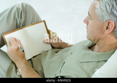 Mature man writing in diary Stock Photo
