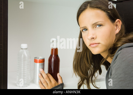 Teen girl next to variety of drinks, reaching for bottled soft drink Stock Photo