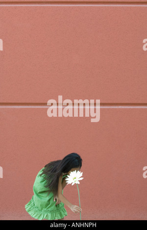 Girl bending over to pick tall flower Stock Photo