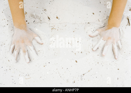 Child making hand prints in sand, cropped view of hands Stock Photo