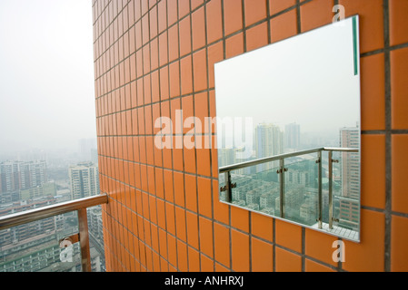Mirror on outer wall reflecting cityscape Stock Photo