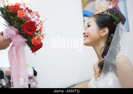 Bride being handed bouquet, cropped view Stock Photo