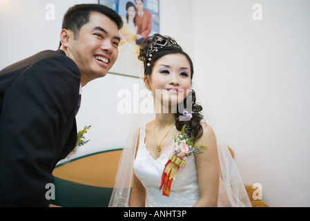 Bride and groom smiling together, looking away Stock Photo