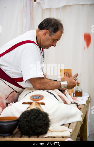 A reenactor dressed as a Roman surgeon or doctor at Chedworth Villa, Gloucestershire, UK Stock Photo