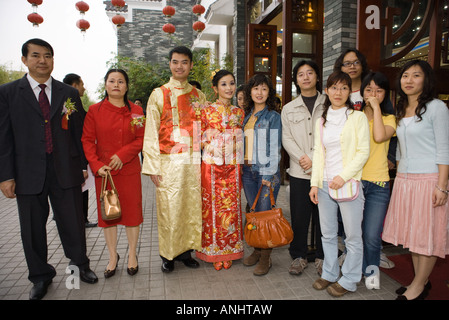 Newlyweds dressed in traditional Chinese clothing, standing with family, group portrait Stock Photo