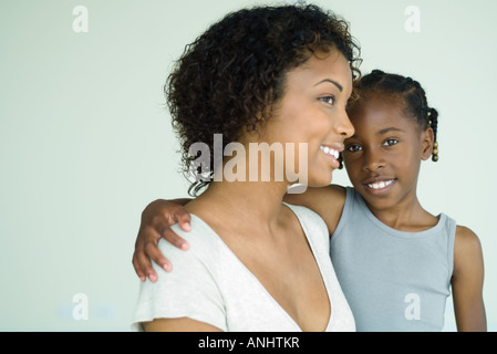 Mother holding daughter, both smiling, girl looking at camera Stock Photo