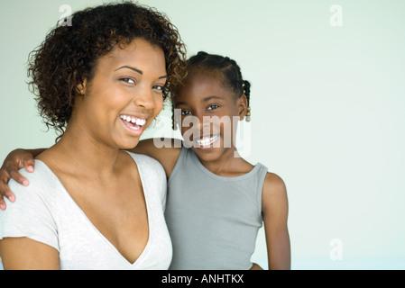 Mother and daughter smiling at camera, close-up, portrait Stock Photo