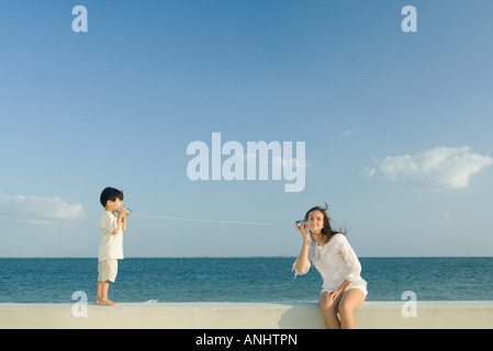 Boy and young woman using tin can phones Stock Photo