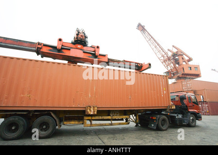 Cargo container being loaded onto truck Stock Photo
