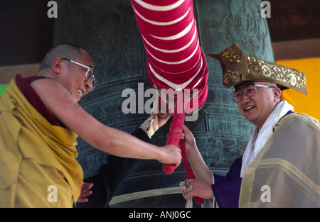 H.H.Dalai Lama rings the giant Japanese temple bell accompanied by a Japanese Buddhist Abbot, Bodh Gaya, Bihar. India Stock Photo