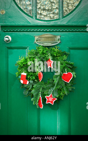 Christmas pine wreath hanging on a green door Stock Photo