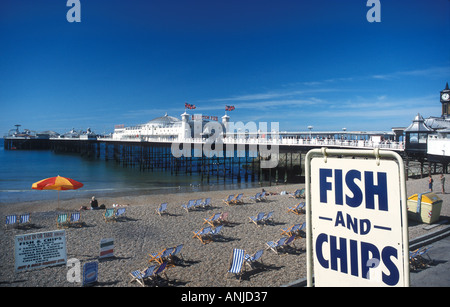 Brighton Pier with deckchairs on beach and fish and Chips sign Brighton East Sussex England Stock Photo