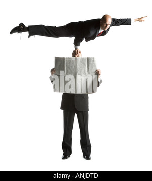 Two male acrobats in business suits performing Stock Photo