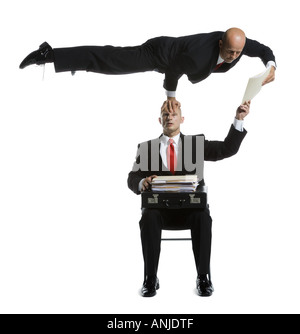 Two male acrobats in business suits performing Stock Photo