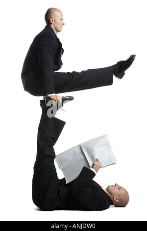 Two male acrobats in business suits performing Stock Photo