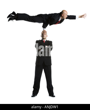 Two male acrobats in business suits performing Stock Photo