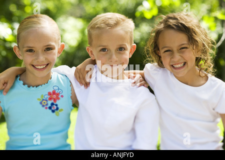 Portrait of two girls and a boy standing side by side and smiling Stock ...