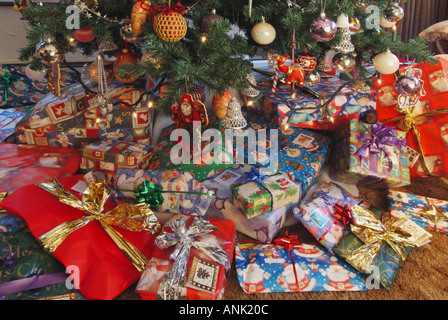 Christmas presents scattered around the base of a Xmas tree in domestic lounge Stock Photo