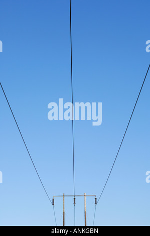 Electricity pylon cables against blue sky Stock Photo