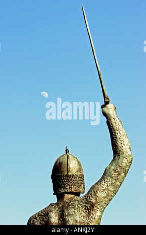 Back view of statue of warrior holding upraised sword at moonset in Maldon,Essex,England,UK Stock Photo