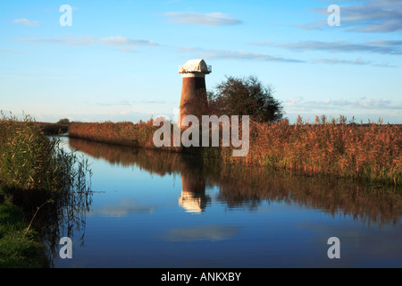 West Somerton Drainage Mill near Horsey, Norfolk, UK, by the River Thurne in late afternoon sun with reflection. Stock Photo