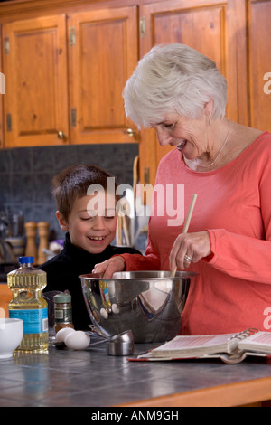 Grandmother cooking or baking in the kitchen with her grandson Stock Photo