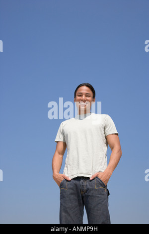Asian man with hands in pockets Stock Photo